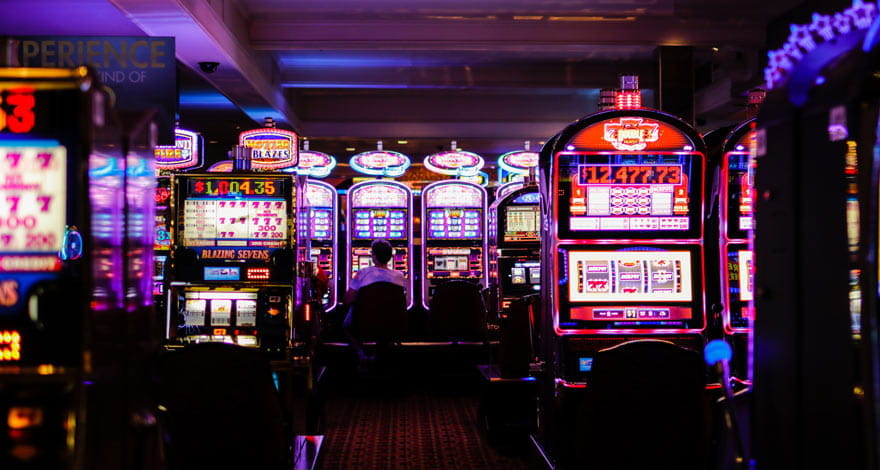 Casino Player Sitting on a Slot Machine at the back of the Floor